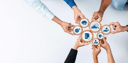 Group of diverse hands collaboratively managing gears with various business icons, symbolizing teamwork and strategy in effective management and leadership. Amityの写真素材