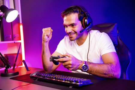 Winner smart streamer playing online game with joystick wearing headphones raising fist up on streaming gamer with social media. Esport skill team player digital at neon light studio room. Surmise.の写真素材
