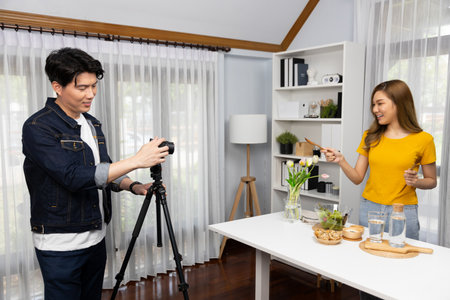 Asian beautiful woman food specialist presenting healthy meal wholegrain bun bread basket on live channel recorded video camera by smart cameraman streaming lifestyle social media online. Infobahn.の写真素材