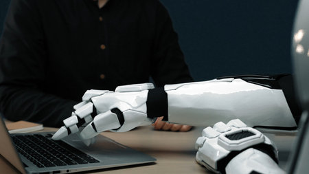 A close-up view of a futuristic robotic arm reaching for a laptop, reflecting innovations in...