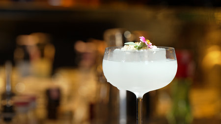 Closeup hand bartender using strainer in vodka coconut smooth fizzy cocktail at luxurious counter preparation making special to guest at fronted bar. Special refresh showcasing nightlife. Vinosity.の写真素材