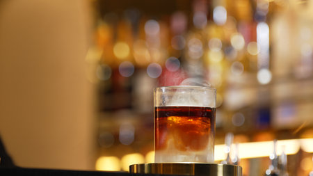 Focusing serving mist smoky classical in Old fashioned of whiskey cocktail presentation on bokeh background recommending special welcome tasty creative advertisement drink at beverage bar. Vinosity.の写真素材