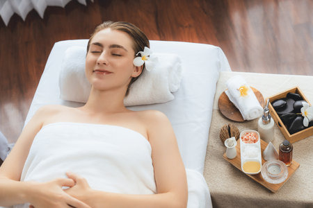 Caucasian woman customer enjoying relaxing anti-stress spa massage and pampering with beauty skin recreation leisure in day light ambient salon spa at luxury resort or hotel. Quiescentの写真素材