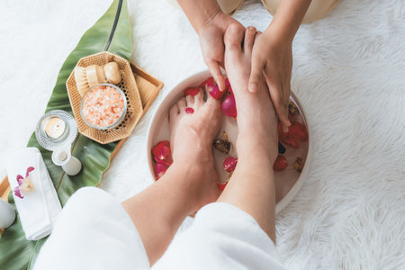 Woman indulges in blissful foot massage at luxurious spa salon while masseur give reflexology therapy in gentle day light ambiance resort or hotel foot spa. Quiescentの写真素材