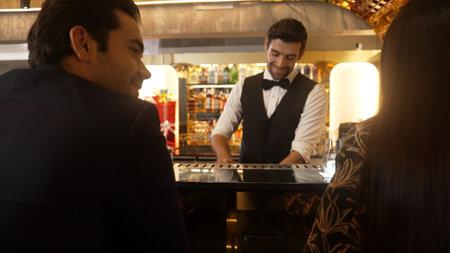 Focusing smiling smart bartender serving gin fizz or tonic soda at luxurious bar, engaging lively...