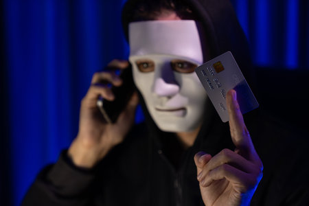 White criminal anonymous mask calling to credit card owner to threaten ransom with privacy information all database, making password encryption by programming hack trying to make insecure. Pecuniary.の写真素材