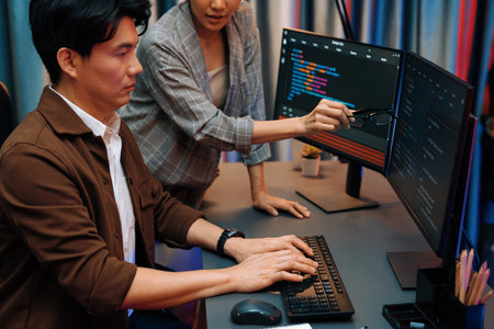 IT developers discussing with point to intelligent website development coder system running data online two screens information technology at neon light room at modern office. Infobahn.の写真素材