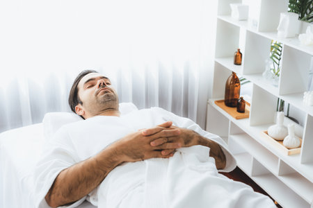 Caucasian man customer enjoying relaxing anti-stress spa massage and pampering with beauty skin recreation leisure in day light ambient salon spa at luxury resort or hotel. Quiescentの写真素材