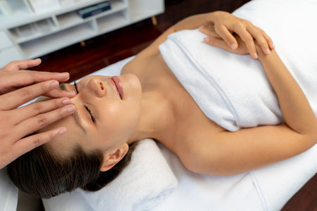 Caucasian woman enjoying relaxing anti-stress head massage and pampering facial beauty skin recreation leisure in dayspa modern light ambient at luxury resort or hotel spa salon. Quiescentの写真素材