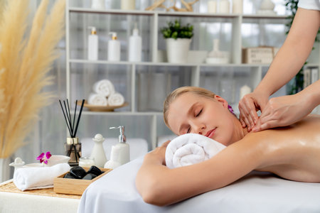 Caucasian woman customer enjoying relaxing anti-stress spa massage and pampering with beauty skin recreation leisure in day light ambient salon spa at luxury resort or hotel. Quiescentの写真素材