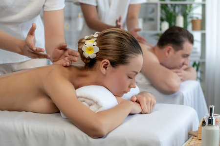 Caucasian couple customer enjoying relaxing anti-stress spa massage and pampering with beauty skin recreation leisure in day light ambient salon spa at luxury resort or hotel. Quiescentの写真素材