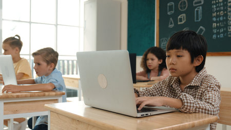 Asian boy working on his laptop while learning about coding engineering prompt at STEM technology...