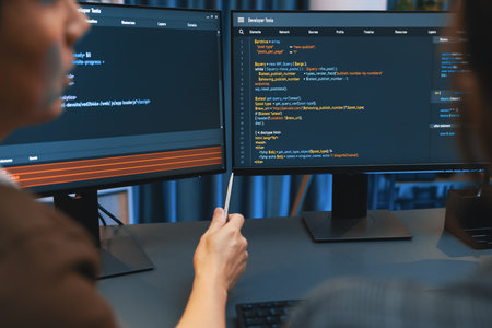 Smart IT developer looking at coding program application on computer screen of online website at...