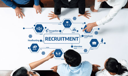 A diverse team collaborates on recruitment strategy in a modern office setting, analyzing graphics related to occupation, employee roles, and interview processes for effective hiring. Amityの写真素材
