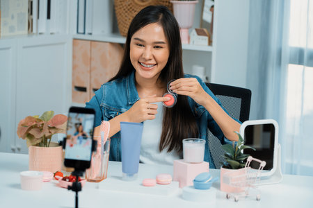 Young beautiful Asian reviewing cosmetic makeup brush cheek testing collection with pastel color,...