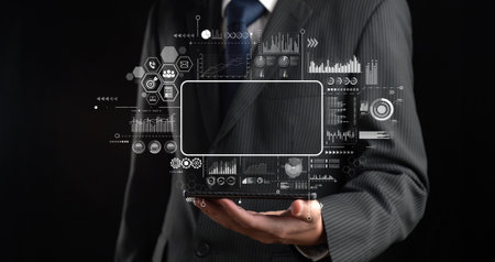 A business professional showcases a tablet displaying big data analytics graphics. This powerful...