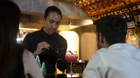Focused on mixed punch cocktail Christmas theme garnishing with burning cinnamon and star anise by...