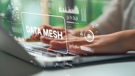Business professional typing on laptop with data mesh concept overlay and analytics visualizations...