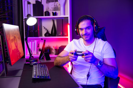 Smart gaming streamer with joystick player looking at camera, playing battle team shooting gun background at warship on pc screen at side view, wearing headset at digital neon light studio. Surmise.の写真素材