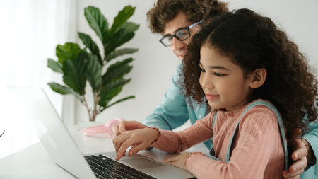 Caucasian father teaching daughter about coding engineering while school girl focus on looking...