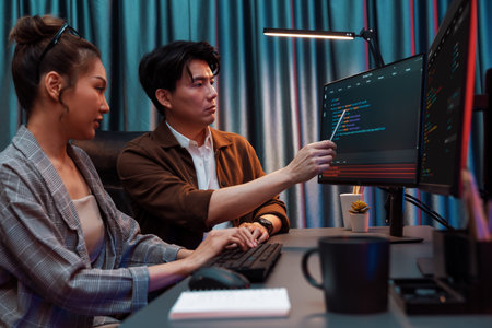IT developers discussing with point to intelligent website development coder system running data online two screens information technology at neon light room at modern office. Infobahn.の写真素材
