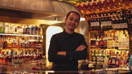 Smart Asian bartender using stirring mixed alcohol syrup into glass with ice for on the rock served mixing looking camera zoom out special refresh cocktail nightlife mixology at nightclub. Vinosity.の写真素材