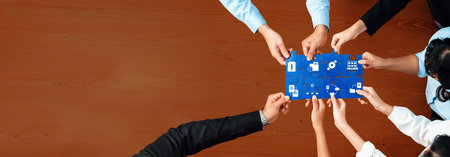A diverse business team gathers around a blue puzzle piece filled with icons, symbolizing their collaborative efforts in management and strategic planning. Amityの写真素材