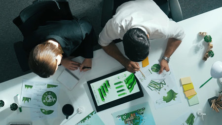 Top down view of business man presenting sustainable idea to manager by using tablet display ESG environmental social governance. Manager working together planning to use clean energy.の写真素材