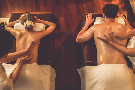Top view couple customer enjoying relaxing anti-stress spa massage and pampering with beauty skin recreation leisure in warm candle lighting ambient salon spa at luxury resort or hotel. Quiescentの写真素材