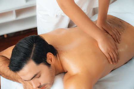 Caucasian man customer enjoying relaxing anti-stress spa massage and pampering with beauty skin recreation leisure in day light ambient salon spa at luxury resort or hotel. Quiescentの写真素材