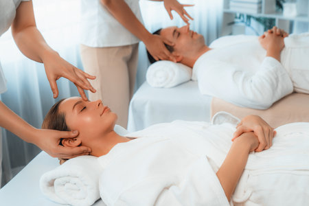 Caucasian couple enjoying relaxing anti-stress head massage and pampering facial beauty skin recreation leisure in dayspa modern light ambient at luxury resort or hotel spa salon. Quiescentの写真素材