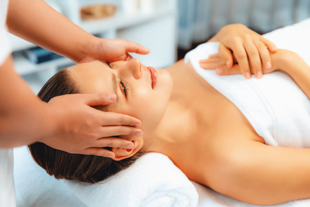 Caucasian woman enjoying relaxing anti-stress head massage and pampering facial beauty skin recreation leisure in dayspa modern light ambient at luxury resort or hotel spa salon. Quiescentの写真素材