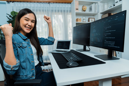 Young Asian IT developer creating raising fist up with successful information on pc with coding program information data application, wearing jeans shirt surround safety analysis screen. Stratagem.の写真素材