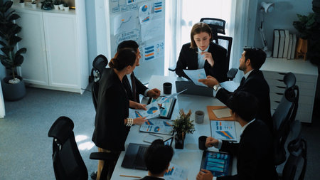 Top view of investor handed financial document to manager while explain marketing idea at meeting table. Diverse people looking at growing graph while listen business team discussion. Directorate.の写真素材