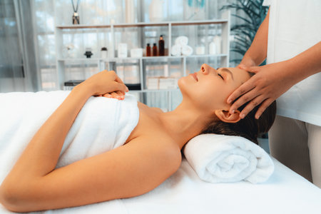 Caucasian woman enjoying relaxing anti-stress head massage and pampering facial beauty skin recreation leisure in dayspa modern light ambient at luxury resort or hotel spa salon. Quiescentの写真素材