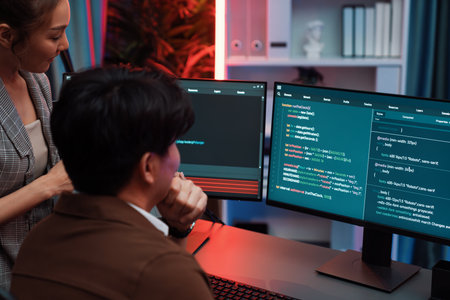 Smart IT developer looking at coding program application on computer screen of online website at back side, analyzing intelligent database system development on business marketing at office. Infobahn.の写真素材
