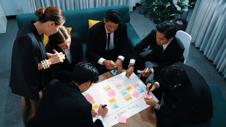 Top view of business people making scrum task board to manage workflow in workplace. Diverse marketing team drawing a line and use colorful stick notes to work on kanban. Creative office. Directorate.の写真素材