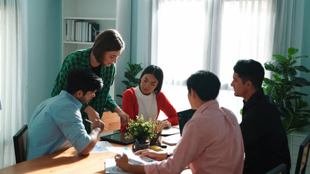 Business woman walking and hold tablet to present marketing plan to group of investor. Creative startup team discussing about financial graph and waving hand to greeting project manager. Convocation.の写真素材