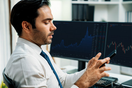 Trader businessman searching on smartphone, analyzing in dynamic stock exchange investment screen on pc with invest highest profitable financial technology market at modern home office. Surmise.の写真素材