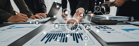 A collaborative business meeting in a modern office featuring hands over data sheets with digital...