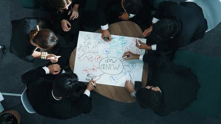 Top down aerial view of group of smart diverse business people brainstorm marketing idea while writing mind map. Creative team working together to share strategy while using mind mapping. Directorate.の写真素材