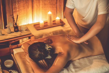 Caucasian woman customer enjoying relaxing anti-stress spa massage and pampering with beauty skin recreation leisure in warm candle lighting ambient salon spa at luxury resort or hotel. Quiescentの写真素材