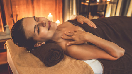 Caucasian woman customer enjoying relaxing anti-stress spa massage and pampering with beauty skin recreation leisure in warm candle lighting ambient salon spa at luxury resort or hotel. Quiescentの写真素材