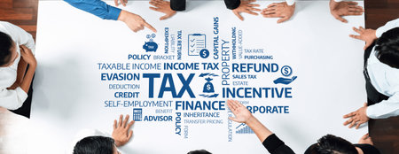Group of Business Professionals Engaged in Tax Planning Discussion with Financial Terms Illustrated on Table Surface for Corporate Strategy Session. Amityの写真素材