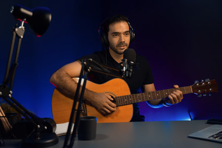 Host channel of smart influencer in creative audio on live streaming to fanclub with sing with play guitar music blogger using headset and mic social media online at neon light modern studio. Surmise.の写真素材
