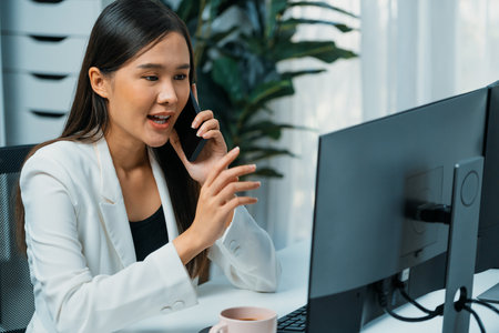 Working young Asian businesswoman calling to customer to present marketing online strategy advertisements analysis service to analyze on social website for planning channel sales target. Stratagem.の写真素材