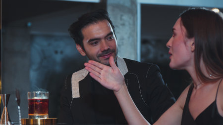 Bartender serving mist smoky classical mixing whiskey with liquor of cocktail to woman tasting with recommending special welcome tasty drink at beverage counter bar to group guests at club. Vinosity.の写真素材