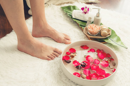 Woman indulges in blissful foot massage at luxurious spa salon while masseur give reflexology therapy in gentle day light ambiance resort or hotel foot spa. Quiescentの写真素材