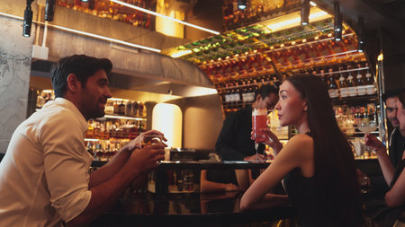 Couple making a toast with cocktail paloma and old fashioned at luxurious bar in lively conversation drinks celebrating a special party at vibrant nightclub while friend drinking Margarita. Vinosity.の写真素材