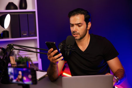 Broadcaster talking to listener on live streaming online with blurred screen, reading comment on...